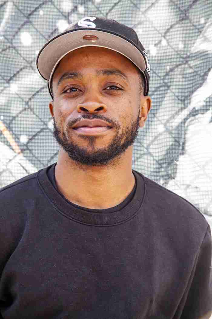 Alden Parkinson in front of one of his photos in Red Hook, Brooklyn. Photo by Pascal DuBois