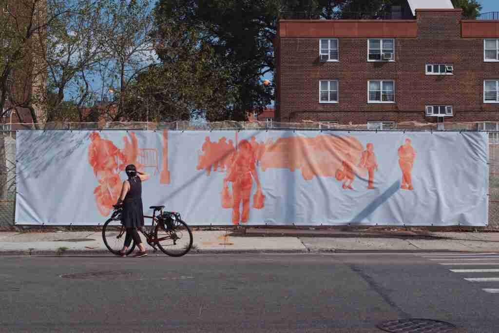 A woman holding her bicycle photographing art
