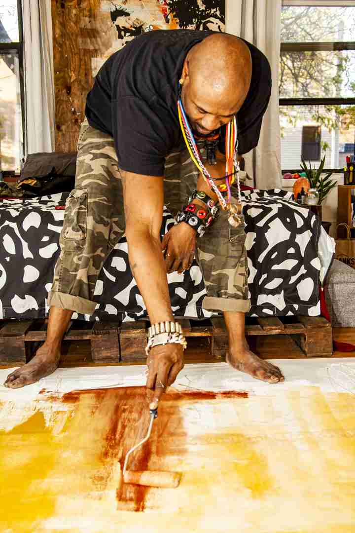 Voodo Fé painting his mural SOAR